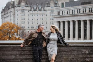 Winter engagement photoshoot of a couple walking together in downtown Ottawa during snowfall