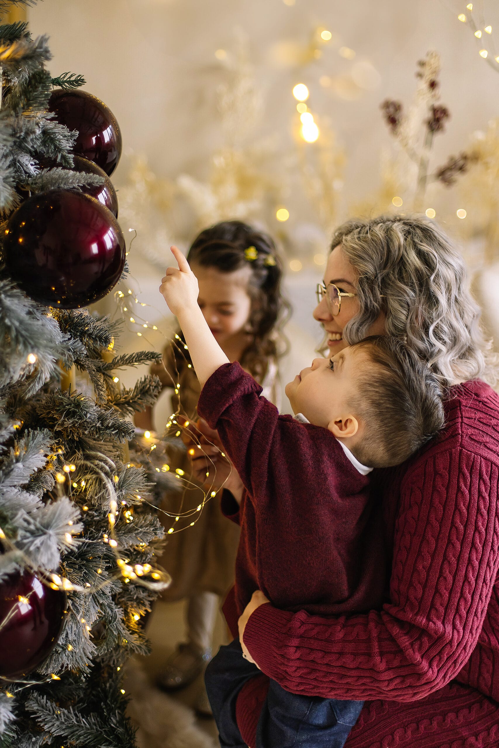 Lifestyle Christmas family portrait of a mother and children decorating a Christmas tree